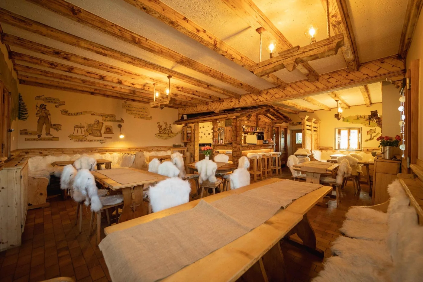 Warm interior dining room with wooden tables and sheepskins