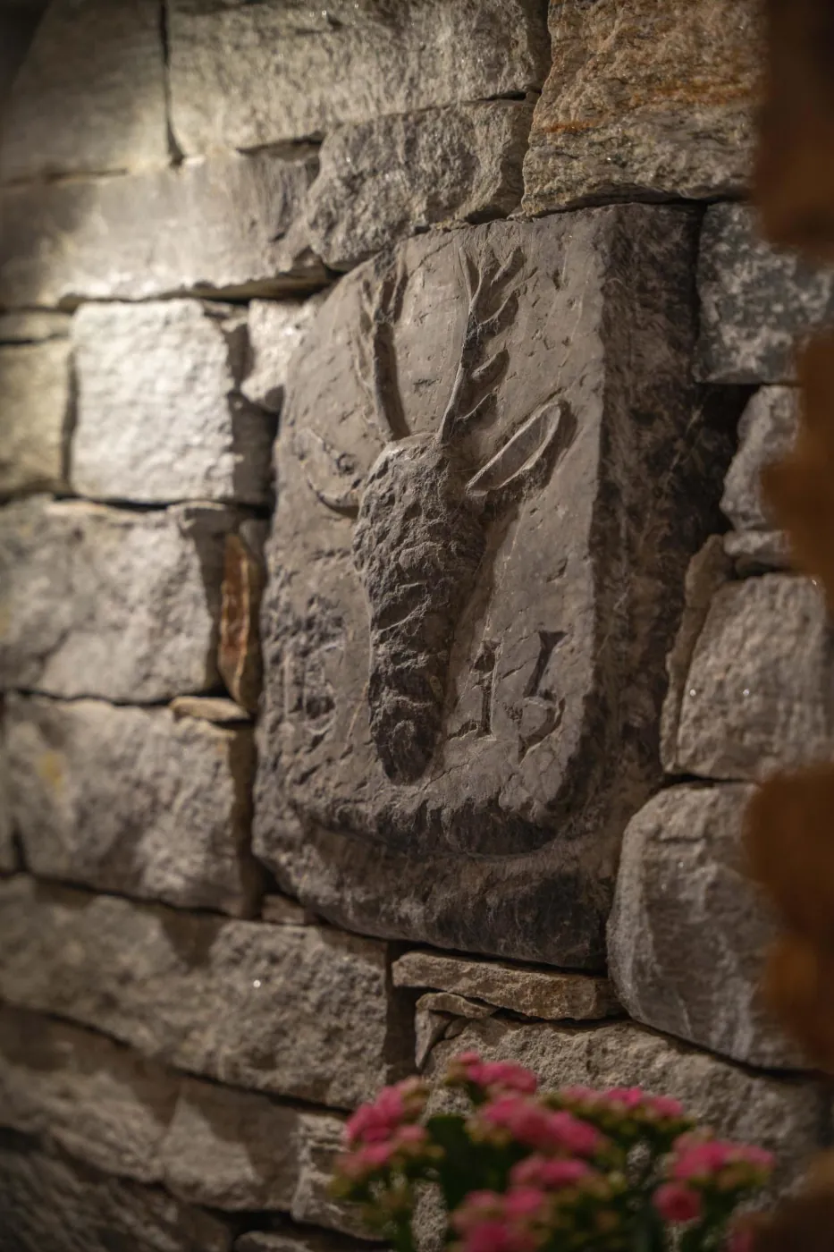 Stag carved in stone on an exposed stone wall