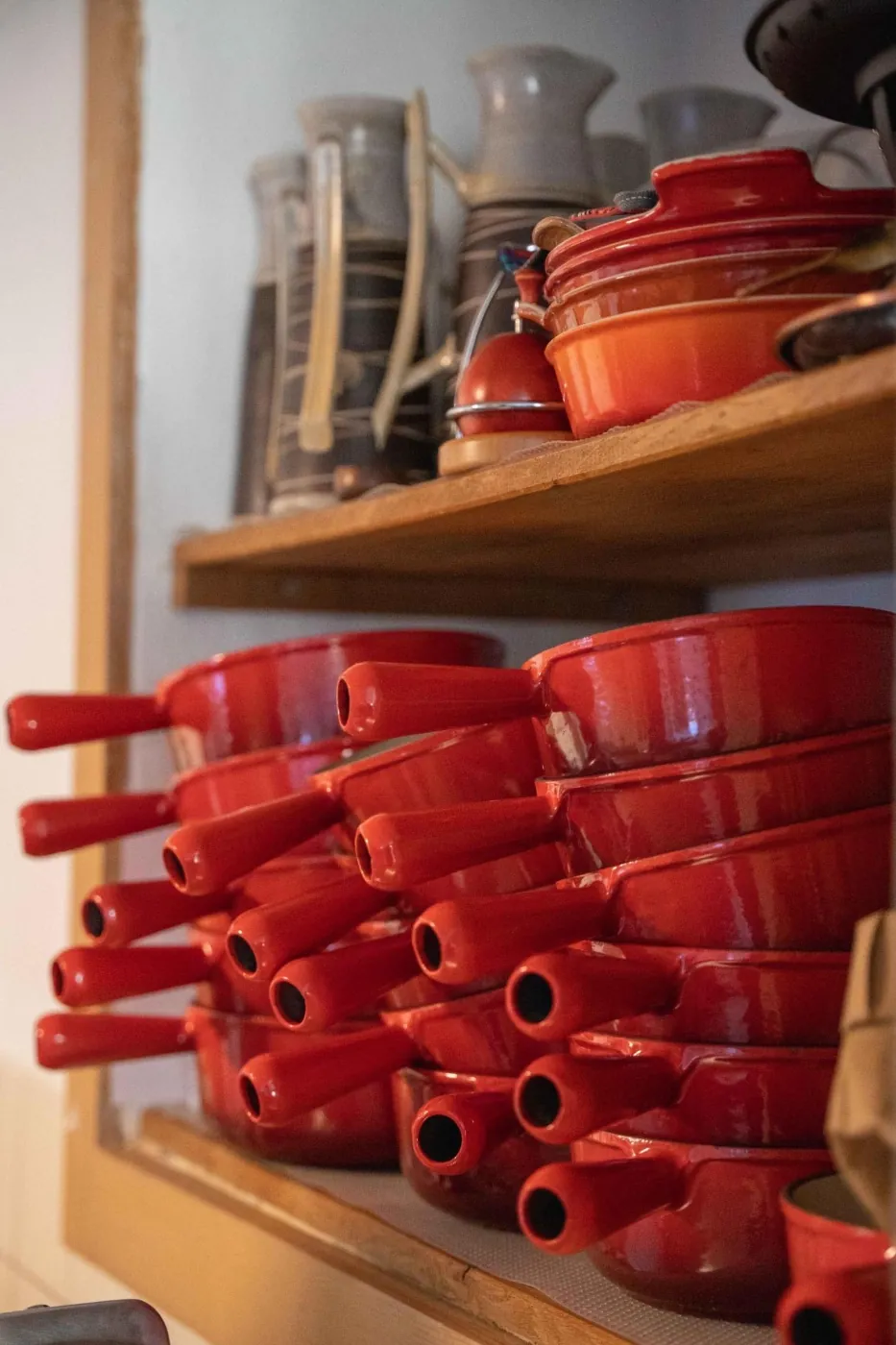 Stack of red fondue pots piled up