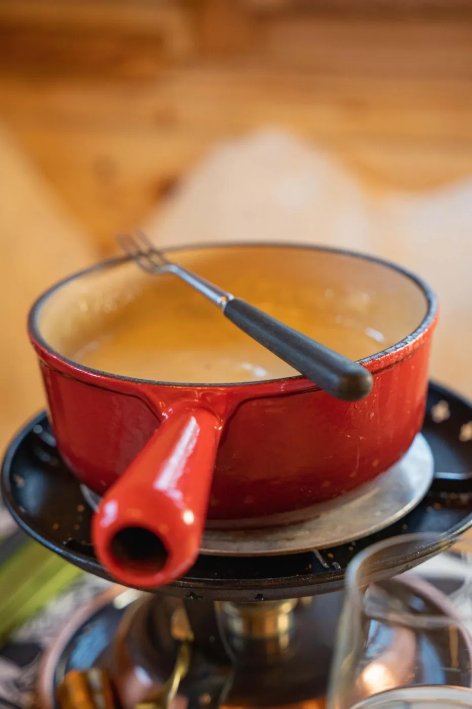 Close-up of a red fondue pot and a fondue fork